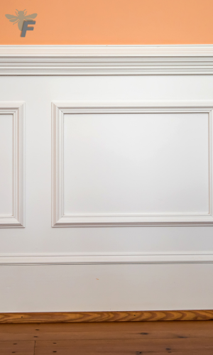 Kitchen wall with white chair rails and orange paint scheme.